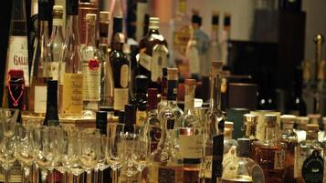 Variedad de botellas de licor y copas de vino a la vista.