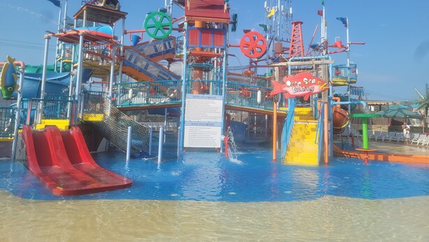 Parque acuático con múltiples toboganes y atracciones acuáticas, incluyendo una zona de 'Deep Sea Fishing'.