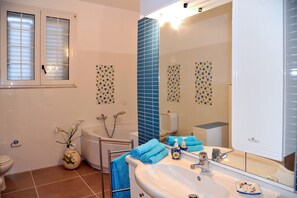 Tina, secadora de cabello, bidet, papel de baño
