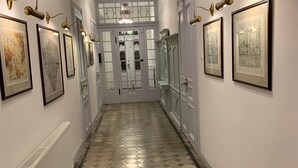 A hallway with patterned flooring, framed artwork on the walls, and a radiator on the left. - Spacious holiday home in Šluknov with private garden (Šluknov)