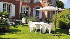 A large house with a well-maintained garden, outdoor seating area, and a covered patio. - Village property in the Perche region with basic shops and SNCF train station. (Sablons sur huisne)