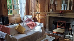 A traditional room with a bed, a wooden chair, a table, and a fireplace. - Village property in the Perche region with basic shops and SNCF train station. (Sablons sur huisne)
