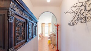 A hallway with a wooden panel, a mirror, and a red coat rack.