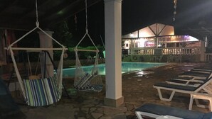 A poolside area with lounge chairs and hammocks.