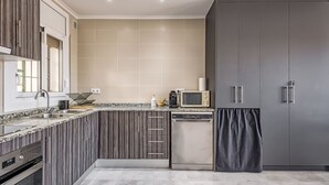 A modern kitchen with a built-in oven, microwave, and dishwasher, featuring a striped backsplash and grey cabinets. - COSTA 2 5 Roses - Immo Barneda (Rosas / Roses)