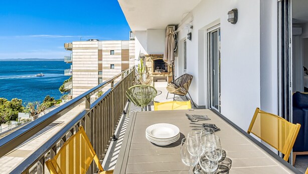 A balcony with a dining setup overlooking the sea, featuring a table with chairs and a view of the ocean. - COSTA 2 5 Roses - Immo Barneda (Rosas / Roses)