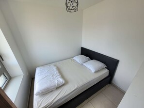 A single bed with a dark headboard in a room with white walls and a skylight. - Studio cabin in Berck-Plage with private parking, wifi included, non-smoking (Berck-Plage)