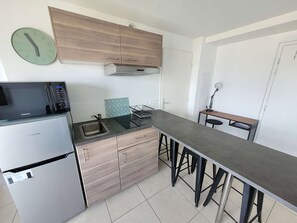 A modern kitchen with a built-in microwave, sink, and wooden cabinets.