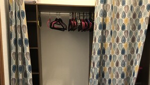 A walk-in closet with patterned curtains, a clothing rack, and a small table. - ?appartement Futuroscope T2 ? Cosyhousebyjanna? (POITIERS)