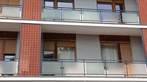 A multi-story building with balconies, a car dealership, and a sign for 'Gierre Auto'. - Attic apartment iPatrizi (Moncalieri)