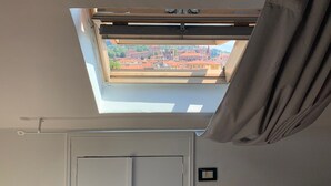 A room with a skylight, a white door, and a radiator. - Attic apartment iPatrizi (Moncalieri)