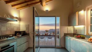Une cuisine moderne dotée d’une porte-fenêtre coulissante donnant sur un balcon offrant une vue panoramique.