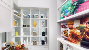 A kitchen with white cabinetry, a fruit basket on the counter, and a coffee machine. - Bed and Breakfast Sorrento 7 Flat (Sorrento)