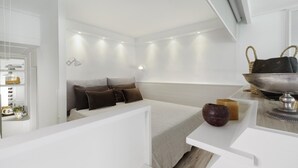 A modern hotel room with a bed, bedside table, and a small seating area. - Bed and Breakfast Sorrento 7 Flat (Sorrento)