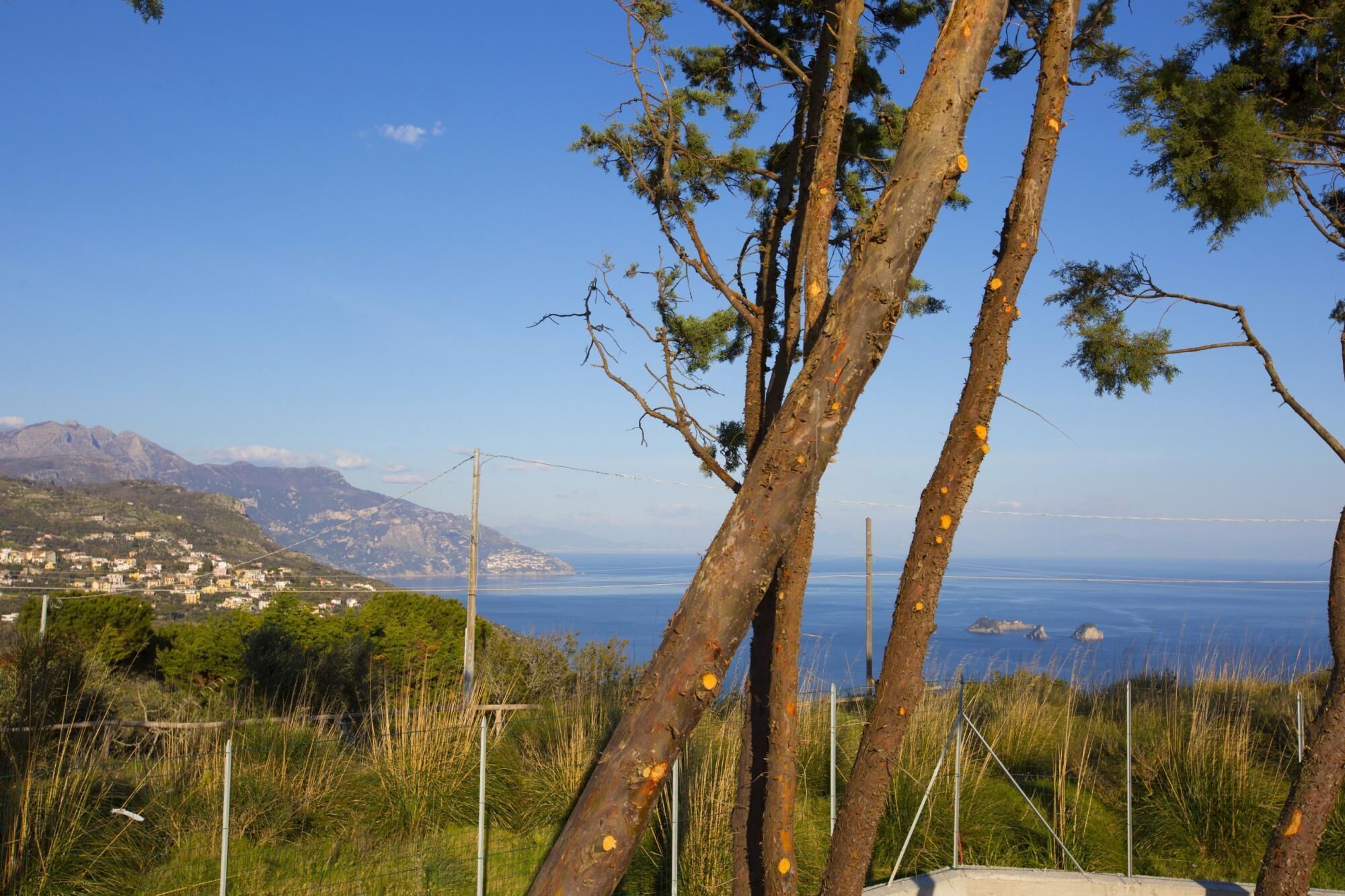 Un paysage côtier offrant une vue sur la mer et les montagnes en arrière-plan.