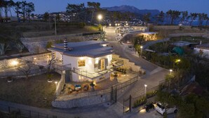 A modern villa with a stone facade, a balcony, and a pool area, surrounded by a landscaped garden and a view of the mountains. - Villa Ligea in Sant Agata sui Due Golfi (Massa Lubrense)