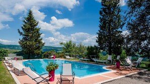 A swimming pool with lounge chairs and a view of the mountains. - Villa Il Giardino in Radicofani (Radicofani)