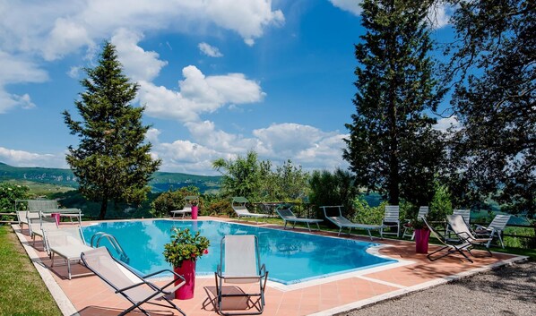 Ein Schwimmbecken mit Liegestühlen und Blick auf die Berge.