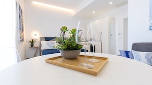 A modern living room with a round white table, a grey sofa, and a blue patterned cushion. - Baia Flegrea Meublè (Bacoli)