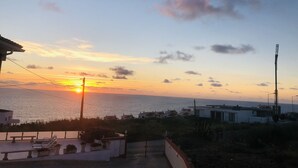A sunset view over a coastal area with residential buildings and a clear sky. - Mae Home-Galaxy (Foz do Arelho)