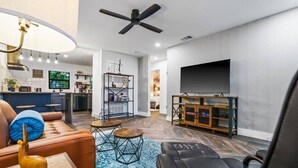 A modern living room with a sofa, coffee table, and TV stand.