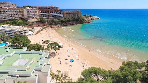 A coastal hotel with multiple floors, a sandy beach, and clear blue waters. - AirCon Apartment · Beachfront · WiFi · UHC SCALA MAR 305 (Salou)