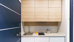A modern kitchen with a stainless steel sink, wooden cabinets, and a white countertop. - GuestHost - Clouds Apartment x3 5 meters from the beach! (Trani)