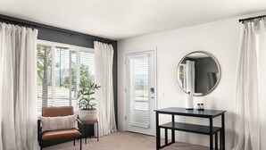 A room with a brown leather chair, a round mirror, a small table, and a potted plant. - Lovely Pet Friendly 2bd / 2ba w/ Private Entrance, On Site Laundry & Dedicated Parking (Paradise)