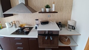 A modern kitchen with a stove, oven, and various appliances like a blender and coffee maker. - Ideal apartment for large families and groups of friends (Corralejo)