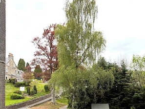 Zona residencial con un edificio de piedra, un sendero y varios árboles.