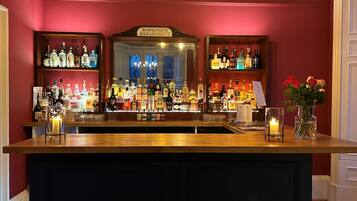 A bar area with shelves of liquor bottles, a sign reading "DISPENSING DEPARTMENT," and a vase with flowers on the counter.