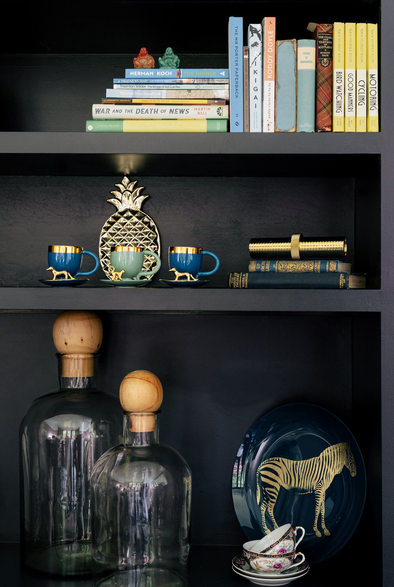 A bookshelf with books and decorative items.