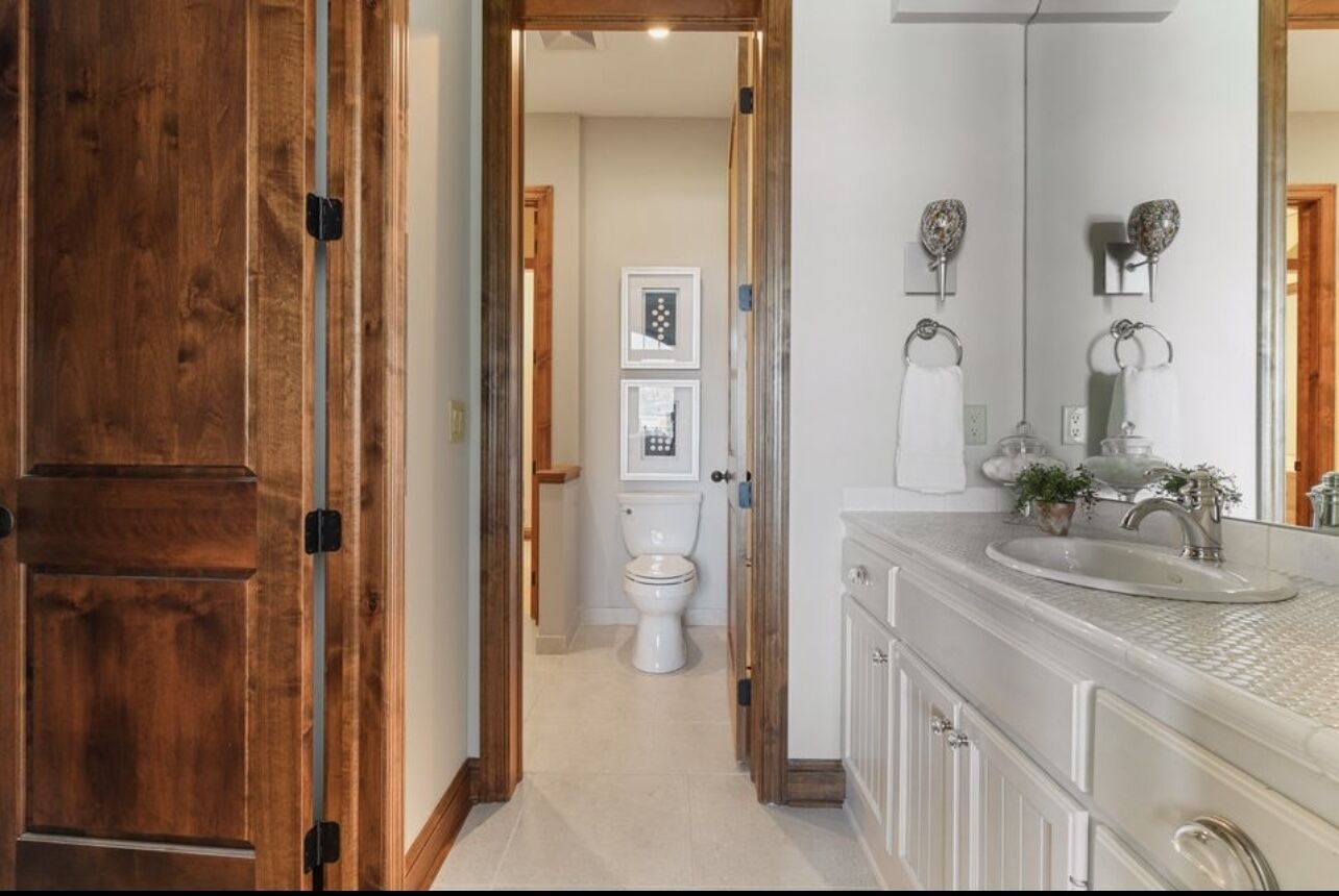 Ein Badezimmer mit großem Spiegel, Waschbecken und Toilette.