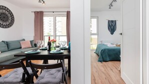 A modern apartment with a dining area, a living room, and a bedroom.