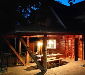 Una cabaña rústica de madera con comedor y una escalera que sube a un nivel superior.