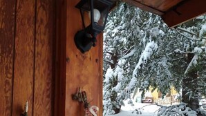 Une cabane en bois, avec un paysage enneigé visible à travers la fenêtre.