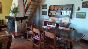 Un comedor rústico con mesa de madera, sillas y chimenea de piedra.