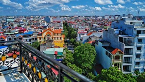 A densely packed urban area with various buildings, including a prominent yellow building with a red roof and a blue building with balconies. - Grand Hill Apartment & Hotel (Hai Phong)