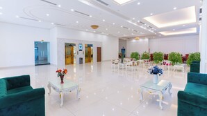 A spacious lobby with a high ceiling, polished floors, and green upholstered seating. - Grand Hill Apartment & Hotel (Hai Phong)
