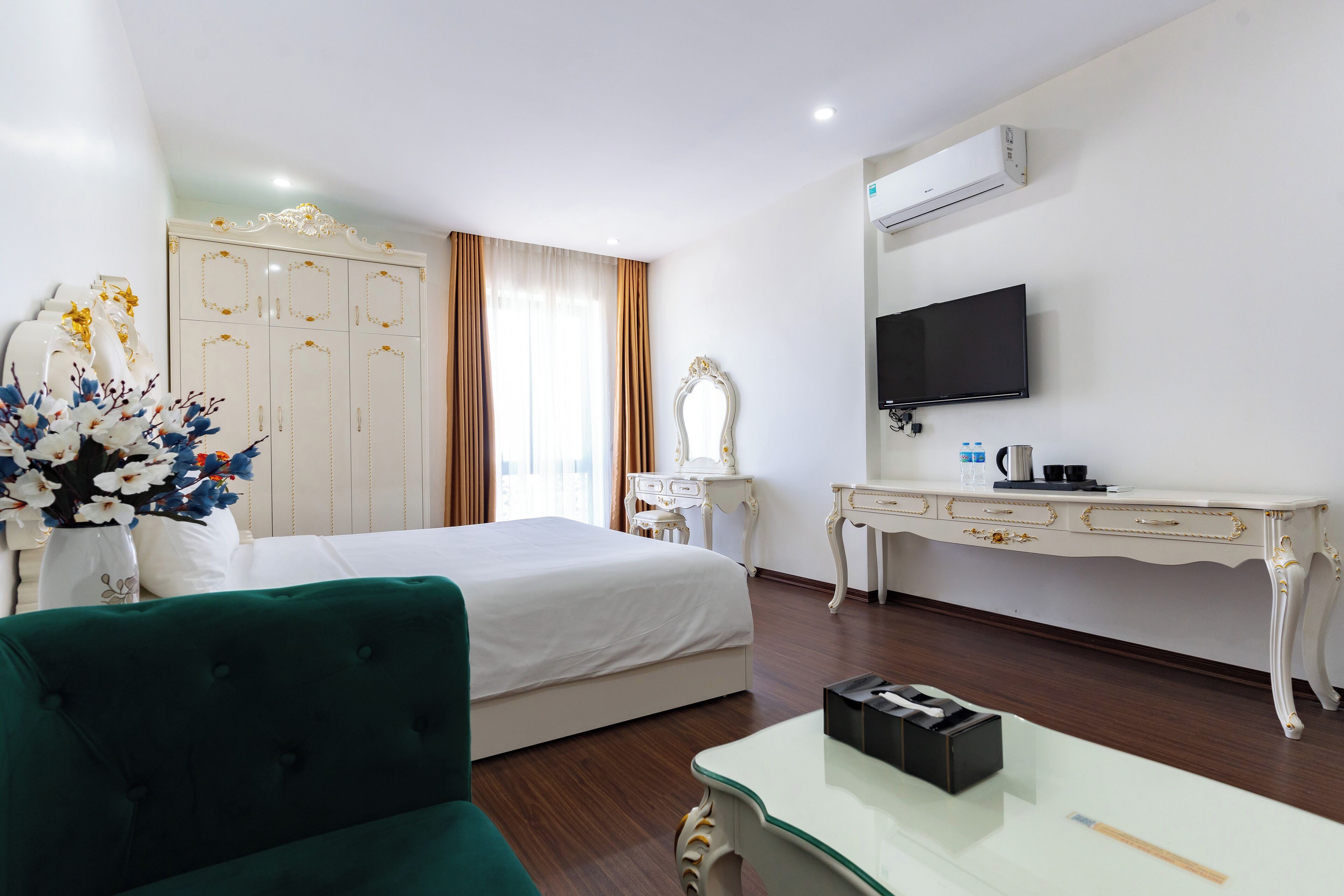 A hotel room with a bed, a desk, a television, and a mirror.