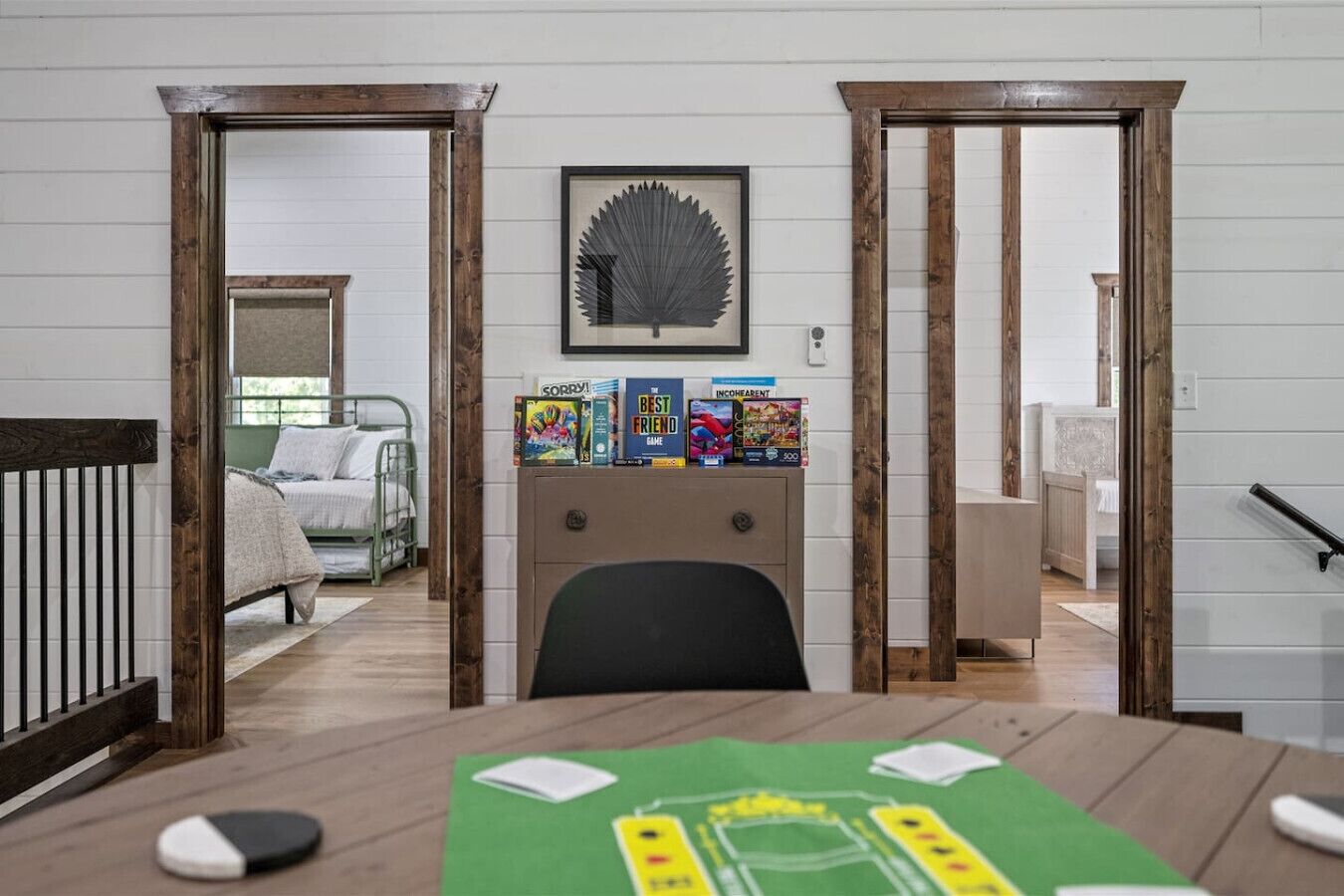 Une pièce avec un lit, un bureau avec des livres et un tableau encadré au mur.
