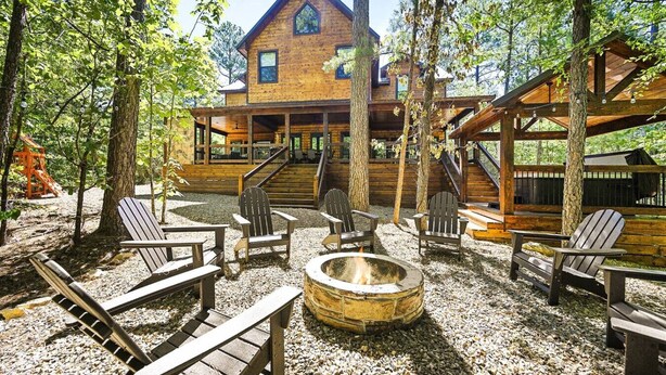 A cabin with a porch, outdoor seating, and a fire pit. - New! Grand Hideaway| Secluded|6 Bedroom (Broken Bow)