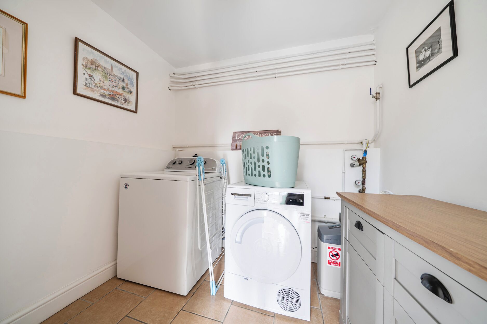 A laundry room with a washing machine, dryer, and stacked laundry baskets.