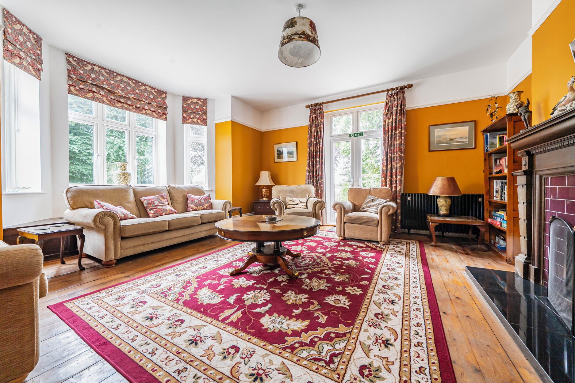 A living room with a fireplace, two sofas, a coffee table, and a patterned rug.