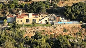 Une maison en pierre dotée d’une piscine, de fenêtres en arc de cercle et d’un escalier en pierre.