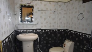 A bathroom with a sink, toilet, and a mirror above the sink. - Clifton Hotel (Balakot)