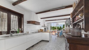 A spacious kitchen with white cabinetry, a large island, and a view of the outdoors. - Villa Amore in Castellammare di Stabia (Castellammare di Stabia)