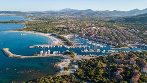 An aerial view of a coastal town with a marina, residential areas, and mountains in the background. - Villa La Bella in Ottiolu (Budoni)