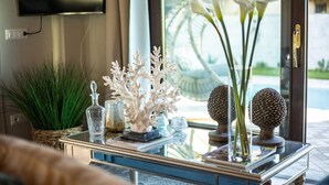 A modern living room with a glass coffee table, decorative items, and a view of a swimming pool. - The Luxury Beach Villa (Viareggio)