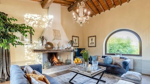 A cozy living room with a fireplace, comfortable seating, and a large window. - Il Conte Farmhouse Retreat (Castelfranco di Sotto)